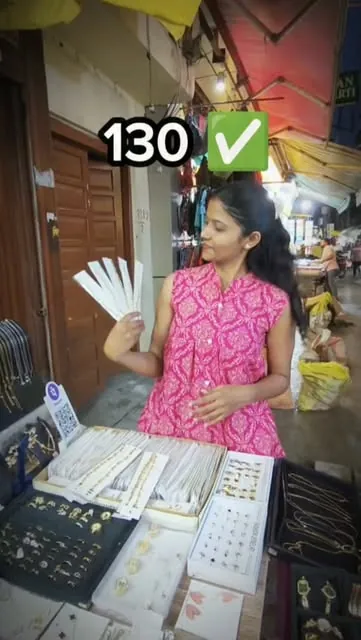 Anjali showing a card of rings at the stall
